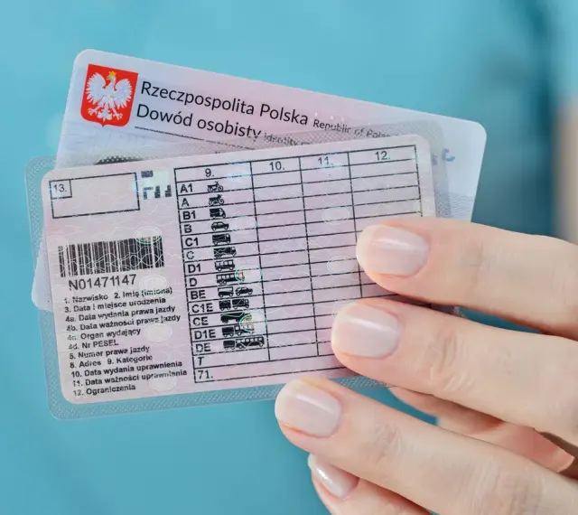 Polskie prawo jazdy z kategoriami, w tym kat. B, w dłoni. Dokumenty do prowadzenia pojazdów.