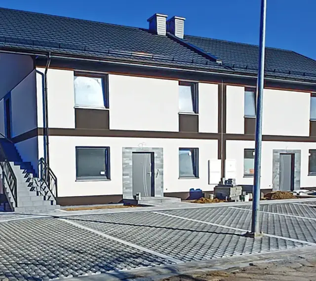 Nowy bliźniak w stanie deweloperskim, gotowy do wykończenia. Nowoczesna elewacja, parking z kostki brukowej.