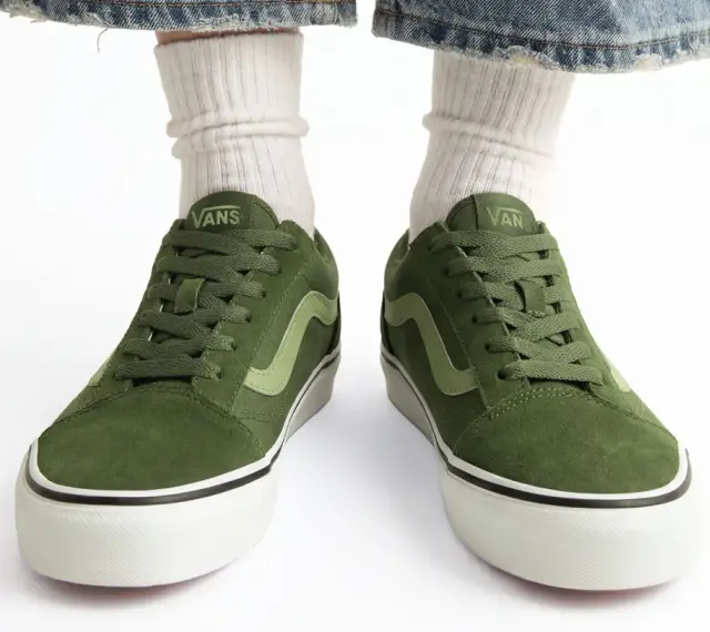 Zielone trampki Vans z jasną falą. Czy to rozmiar buta 11.5 cm? Białe skarpetki i podarte jeansy dopełniają stylizację.