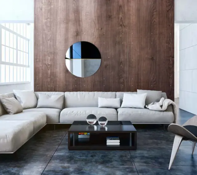 Nowoczesny salon w stylu bauhaus z szarą sofą, drewnianą ścianą i designerskim fotelem.