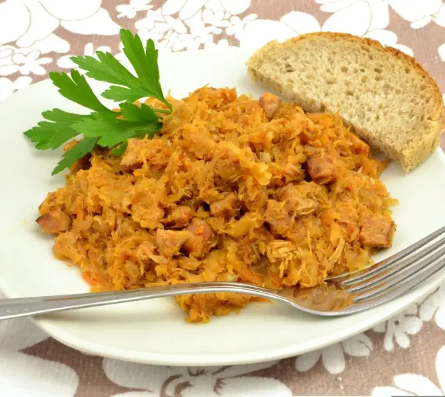 Tradycyjny polski bigos przepisy mistrzów. Aromatyczny gulasz z kapusty i mięsa, podany z chlebem i natką pietruszki.
