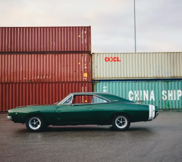 Klasyczne amerykańskie samochody, zielony Dodge Charger z lat 60. na tle kontenerów portowych.