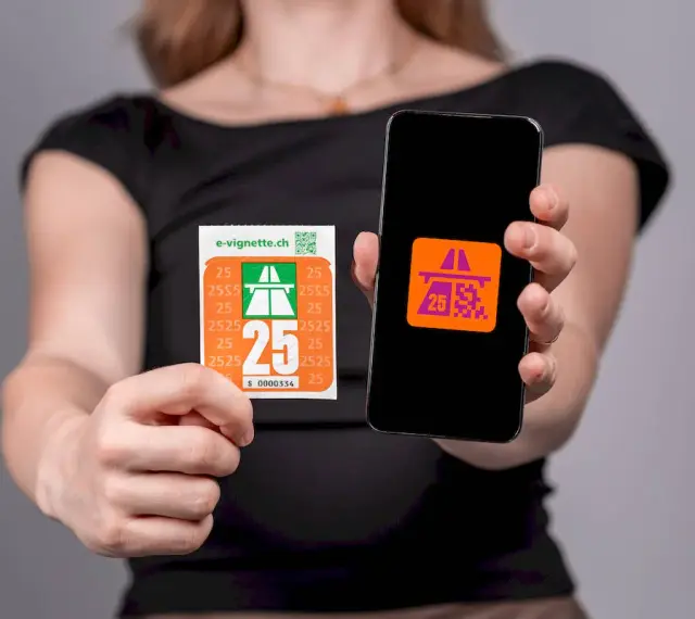 Kobieta trzyma w dłoniach winietę szwajcaria i smartfon z aplikacją.