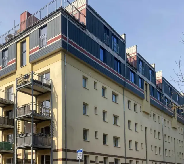 Modernes Mehrfamilienhaus mit Balkonen und auffälliger Fassadengestaltung im **Vorort**.