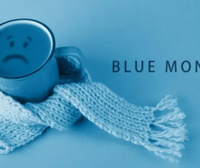 Smutny kubek z uśmiechem, otulony szalikiem, symbolizuje blue monday.