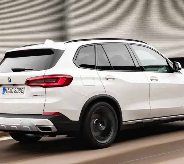 Białe BMW X5 M50d pędzi po autostradzie, zostawiając za sobą rozmyte tło.
