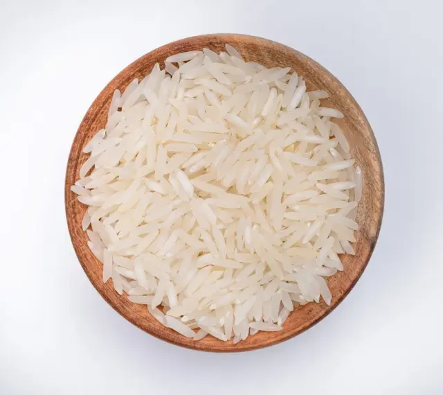Miseczka z ryżem parboiled na białym tle.