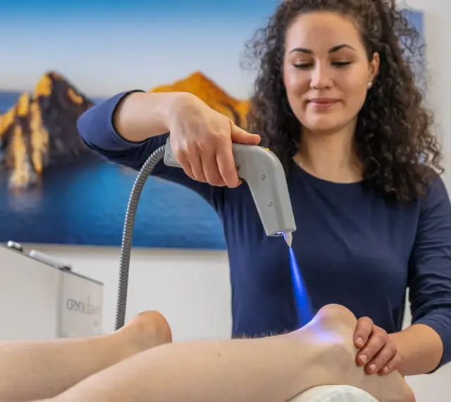 Therapeutin behandelt Fersensporn mit Kälteanwendung. Die Cryo-Therapie lindert Schmerzen, wie bei Liebscher & Bracht empfohlen.