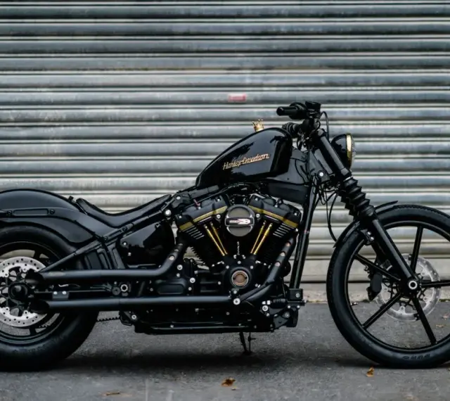 Czarny Harley-Davidson Dyna z błyszczącym lakierem i złotymi akcentami na silniku, gotowy do drogi.