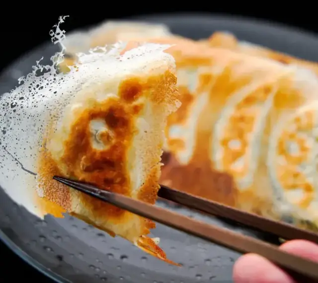 Chrupiące gyoza z delikatną, koronkową skórką, podniesione pałeczkami. Idealny przepis na gyoza!