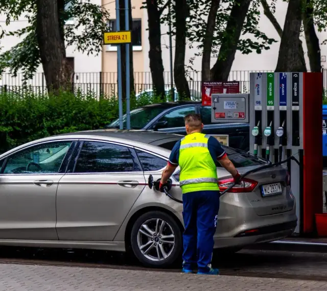 Pracownik stacji paliw tankuje samochód. Rosnące ceny paliwa to problem, który dotyka każdego kierowcę.
