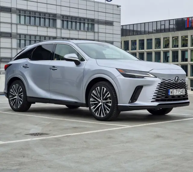 Eleganckie japońskie auta, jak ten srebrny Lexus, prezentują się nowocześnie na tle biurowców.