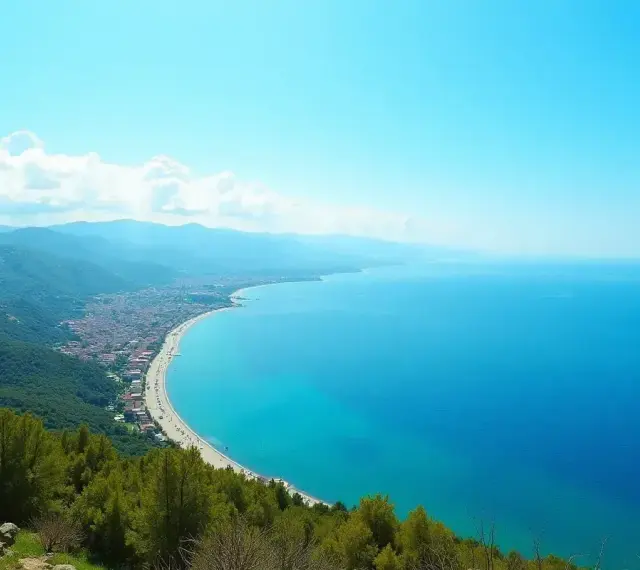 Widok na turkusowe morze, piaszczystą plażę i górzyste wybrzeże Turcji.