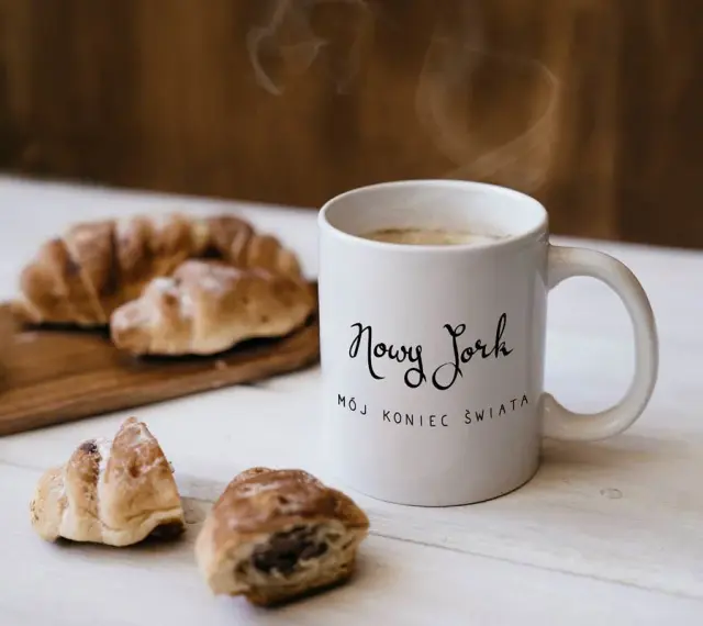 Kawa i croissanty, idealne na śniadanie. Kubek z napisem "Nowy Jork, mój koniec świata" to świetny pomysł, co kupić w USA do Polski.