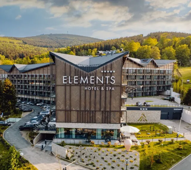 Nowoczesny hotel przy stoku narciarskim w Polsce, Elements Hotel & Spa, otoczony zielenią i górami. Idealne miejsce na zimowy wypoczynek.