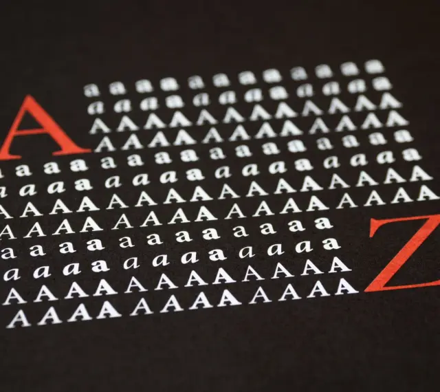 Duża czerwona litera "A" i rzędy białych liter "a" i "A" na czarnym tle, ilustrujące **kerning**. Obok czerwona litera "Z".