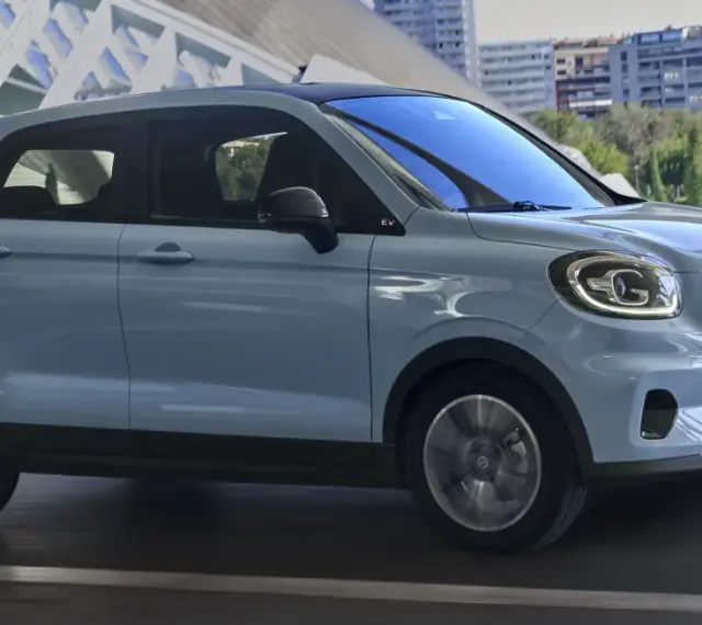 Jasnoszary Leapmotor T03 na tle nowoczesnej architektury. Sprawdź, jaka jest leapmotor t03 cena i czy to auto dla Ciebie.