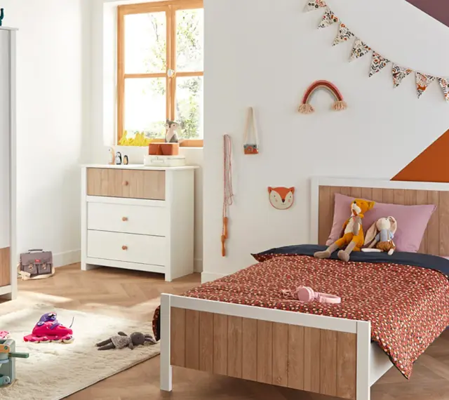 Chambre d'enfant décorée avec un lit, une commode, une armoire et des jouets.