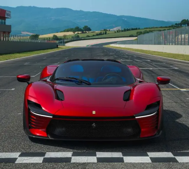 Czerwone Ferrari Daytona SP3 na linii startu toru wyścigowego, gotowe do przekroczenia mety.