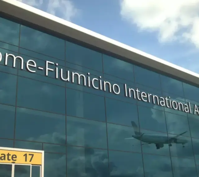 Fasada lotniska Rome-Fiumicino International Airport z napisem i odbiciem samolotu.
