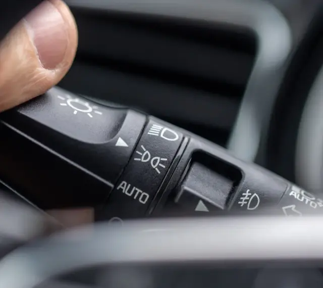 Palec naciska przełącznik świateł, wybierając, na jakich światłach się jeździ: auto, mijania lub drogowe.