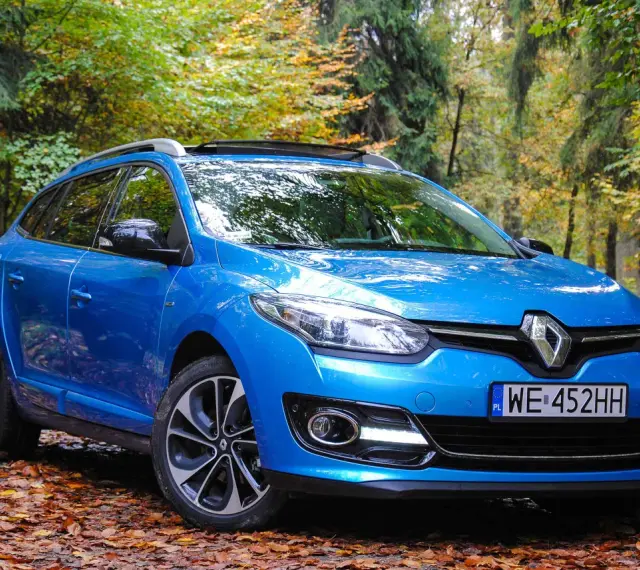 Niebieski Renault Megane 2 1.6 16v na tle jesiennego lasu.