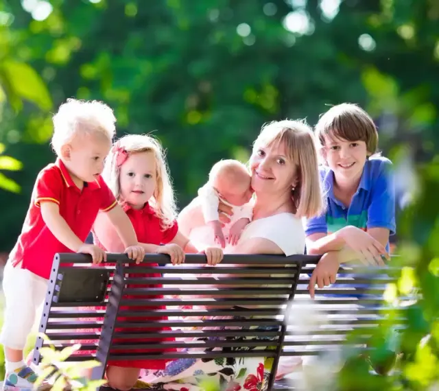 Szczęśliwa mama z czwórką dzieci, marząca o emeryturze dla matek 4 dzieci, które pracowały.