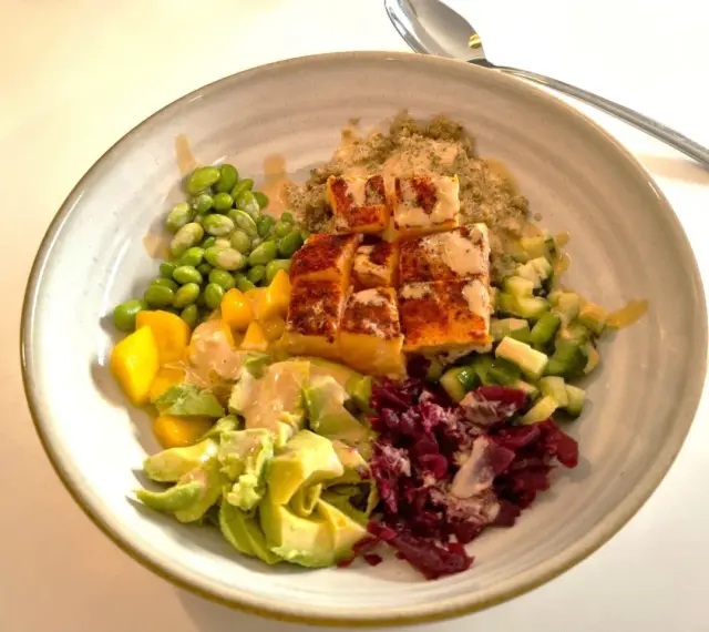 En vacker och hälsosam middagsbowl med lax, quinoa, edamamebönor, mango, avokado och rödbetor. Ett perfekt recept för en snabb och god middag.