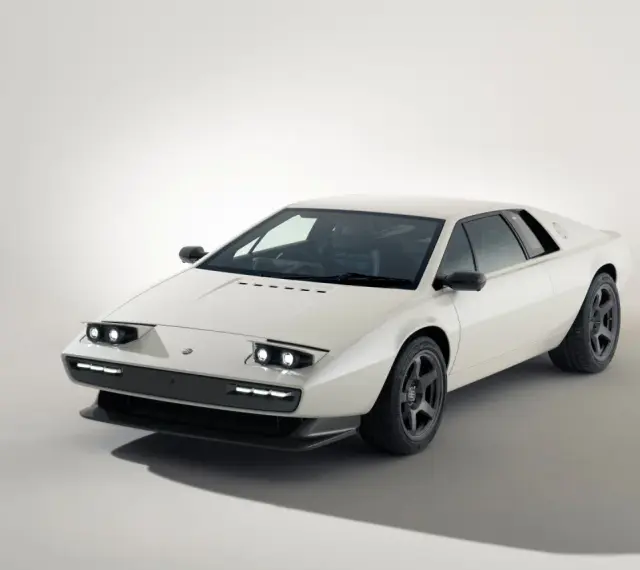 Biały Lotus Esprit z lat 80. z charakterystycznymi podnoszonymi światłami i sportowymi felgami.