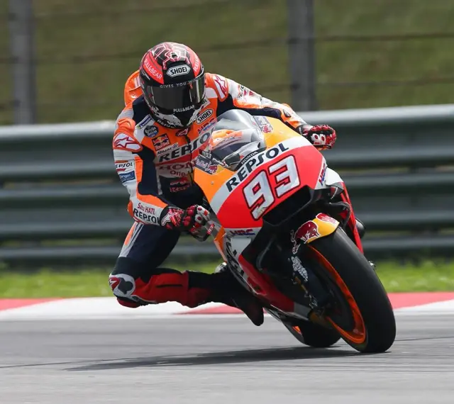 Motocyklista w kombinezonie Repsol Honda z numerem 93 wykonuje ostry zakręt, stosując technikę przeciwskrętu.