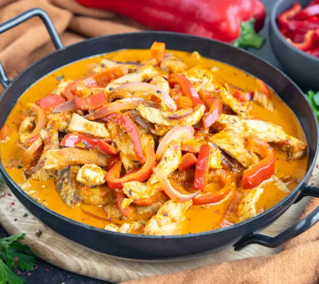 Ein einfaches Putengeschnetzeltes-Rezept mit Paprika und Zwiebeln in cremiger Sauce, serviert in einer Pfanne.