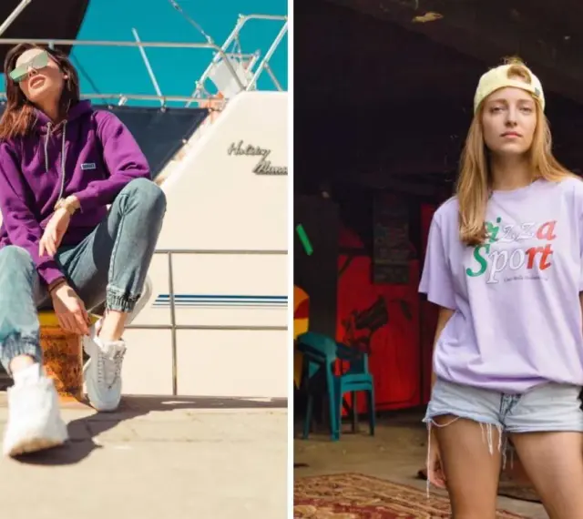 Dwie kobiety w modnych stylizacjach streetwear. Jedna w fioletowej bluzie i jeansach, druga w liliowej koszulce z napisem "Pizza Sport". Polskie marki odzieżowe streetwear w akcji.