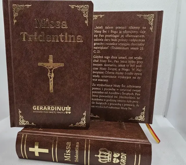 Brązowe księgi z napisem "Missa Tridentina" i złotym krzyżem. Jedna otwarta, z tekstem o Mszy Świętej.