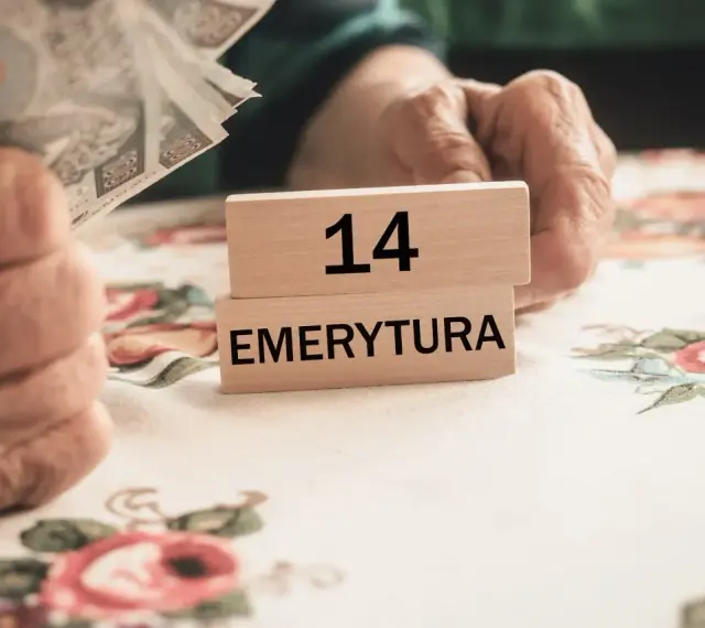 Dłonie trzymają pieniądze obok drewnianych klocków z napisem "14 EMERYTURA".