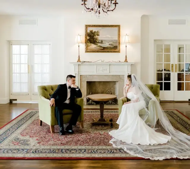 Para młoda w eleganckich strojach siedzi naprzeciwko siebie, rozmawiając o tym, co daje ślub cywilny.