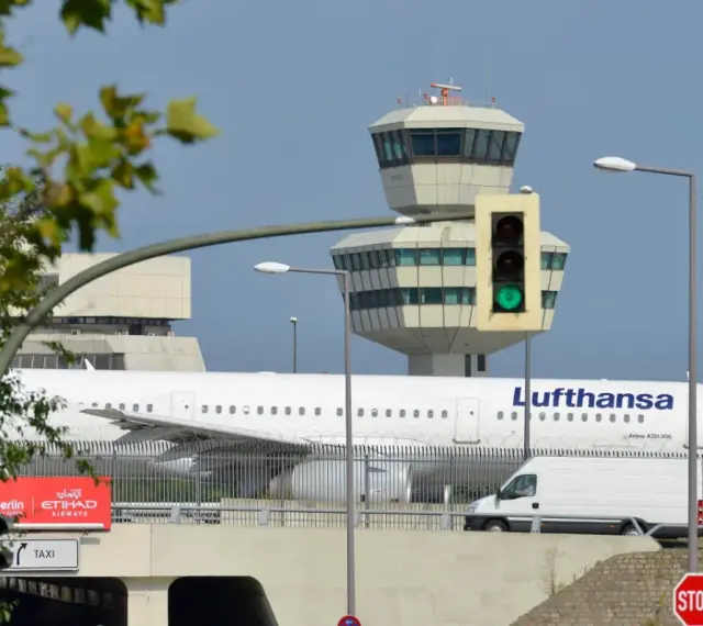 Lufthansa samolot na tle wieży kontroli lotów. To największe lotnisko w Europie, gdzie ruch jest zawsze intensywny.