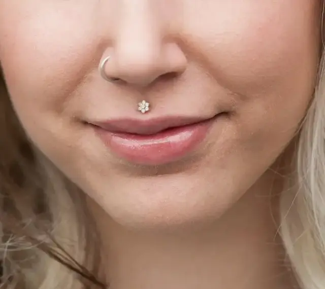 Delikatny piercing ust w kształcie kwiatka, ozdoba twarzy. Dowiedz się, co to piercing i jak podkreśla urodę.