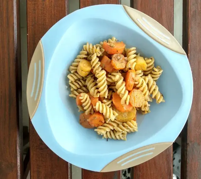 Kolacja dla niemowlaka 9 miesięcy: makaron fusilli z marchewką i ziemniakami, doprawione ziołami.