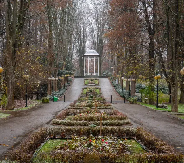 Polanica Zdrój co warto zobaczyć: jesienny park z altaną i alejkami, ozdobnymi rabatami i latarniami.