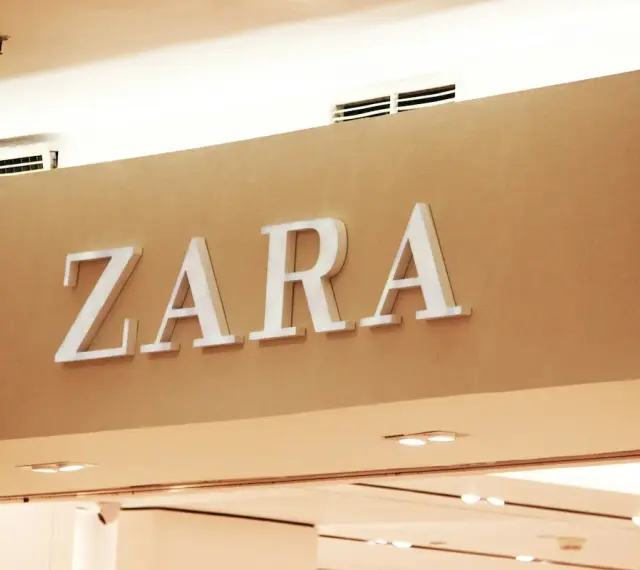 ZARA, znana marka odzieżowa, prezentuje swoje logo na jasnobrązowej ścianie.