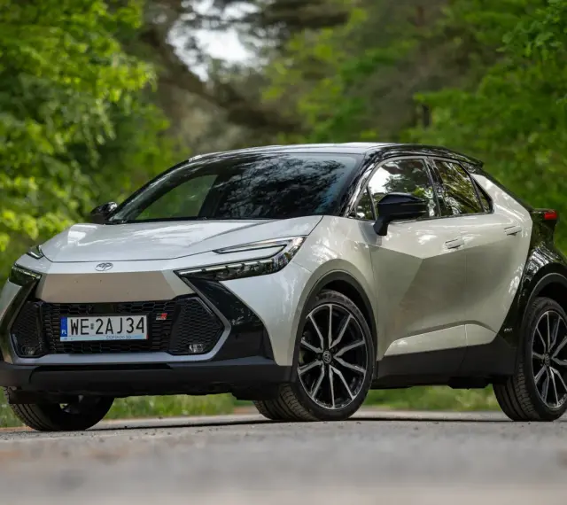Nowa Toyota C-HR 2025 w kolorze srebrno-czarnym, zaparkowana na leśnej drodze.