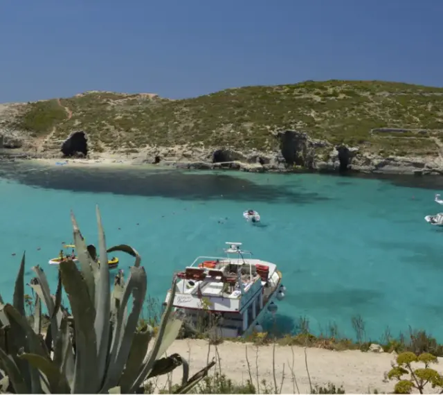 Malta wakacje: turkusowa woda, skaliste wybrzeże z jaskiniami i łodzie. Idealne miejsce na relaks.