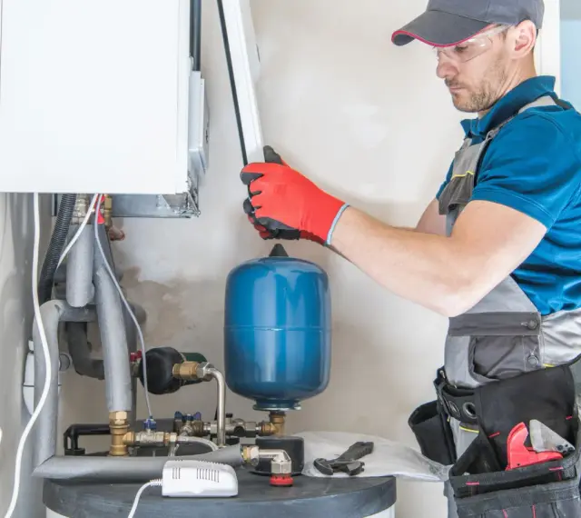 Instalator sprawdza podzespoły kotła gazowego. Zastanawiasz się, ile kosztuje piec gazowy?