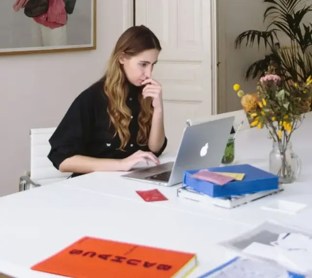 Junge Frau mit guten EDV-Kenntnissen arbeitet konzentriert an ihrem Laptop in einem hellen Büro.