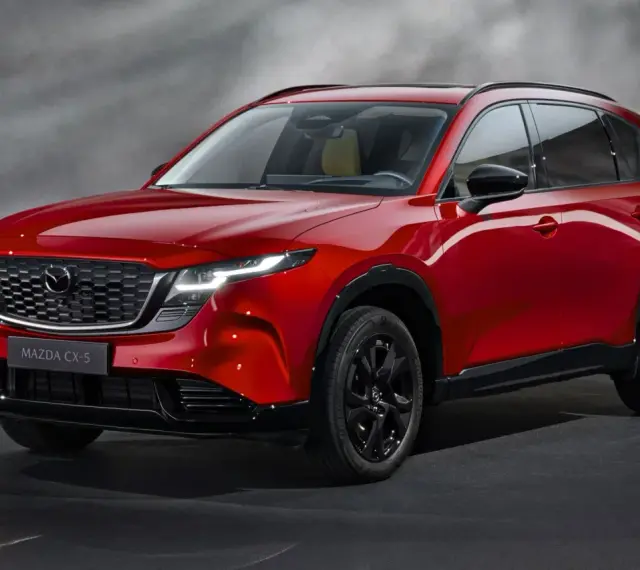 Czerwony Mazda CX-5, jeden z wielu stylowych japońskich samochodów, prezentuje się elegancko na ciemnym tle.