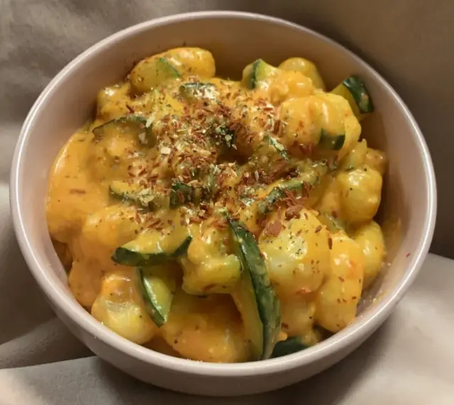 Puszyste gnocchi z cukinią w kremowym sosie, posypane ziołami i płatkami chili. Pyszne gnocchi z pesto w nowej odsłonie.