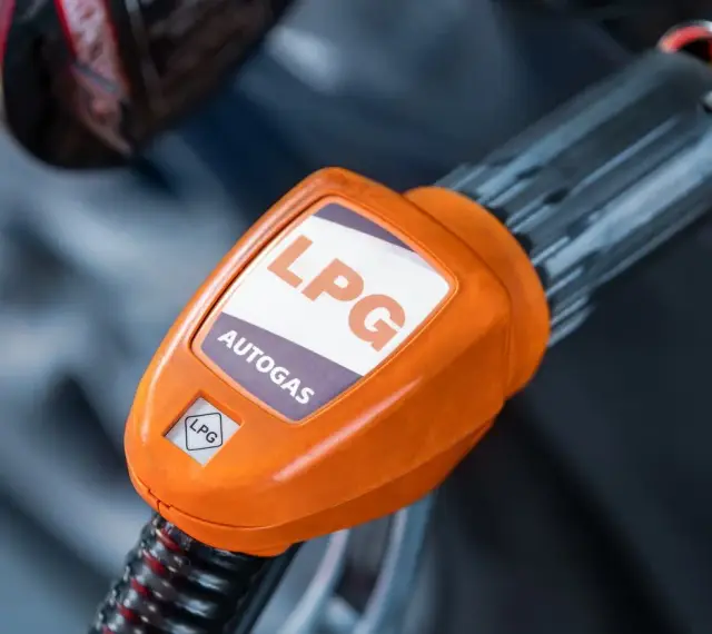 Pomarańczowa końcówka dystrybutora LPG z napisem "AUTOGAS". Rozważasz koszt instalacji gazowej?