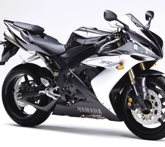 Sportowy motocykl Yamaha R1, jedna z wielu generacji, w kolorze czarno-białym, prezentuje się dynamicznie na białym tle.