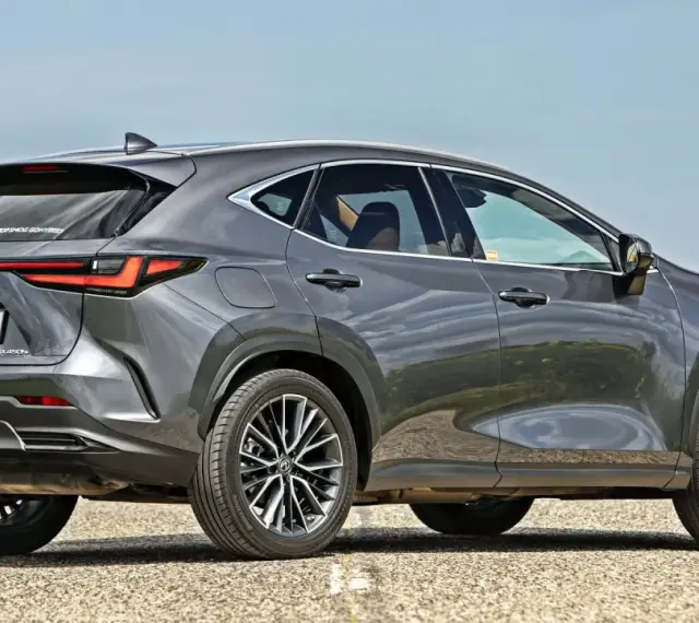 Szary Lexus NX 450h+ na drodze, w tle pole rzepaku. Sprawdź aktualną lexus nx cena.