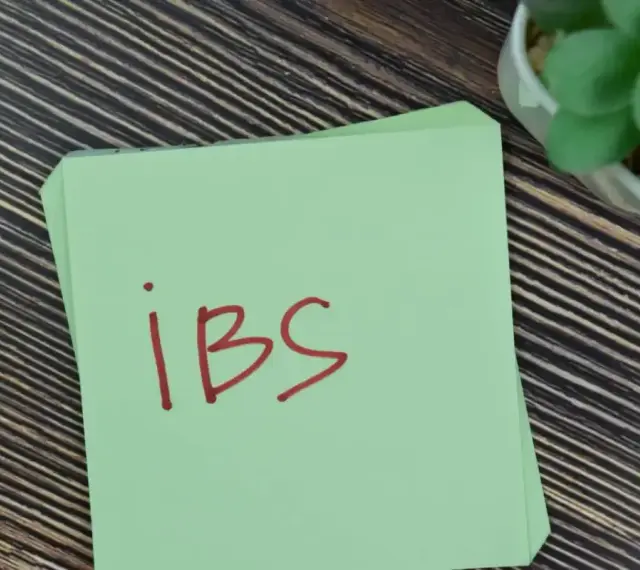 Na zielonej kartce napisano "IBS". Może to przypomnienie o lekach, takich jak Duspatalin, które pomagają w łagodzeniu objawów zespołu jelita drażliwego.